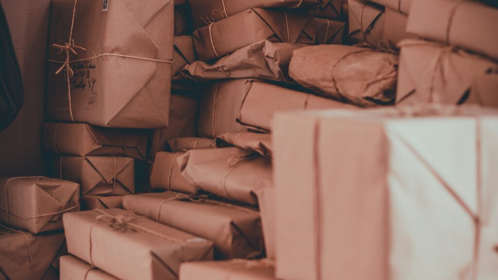 Stacks of parcels wrapped in brown paper and tied with string, ready to be posted